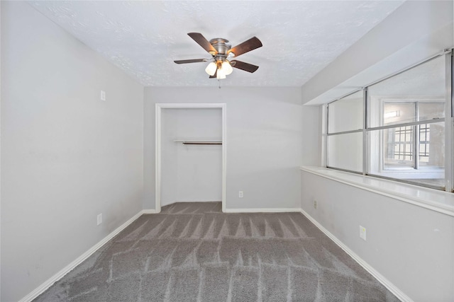 unfurnished bedroom with carpet flooring, baseboards, and a textured ceiling