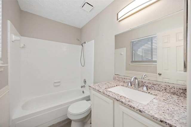 bathroom with visible vents, toilet, a textured ceiling, bathing tub / shower combination, and vanity