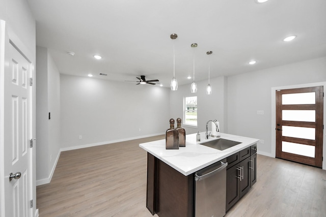 kitchen featuring light wood finished floors, recessed lighting, a sink, light countertops, and stainless steel dishwasher