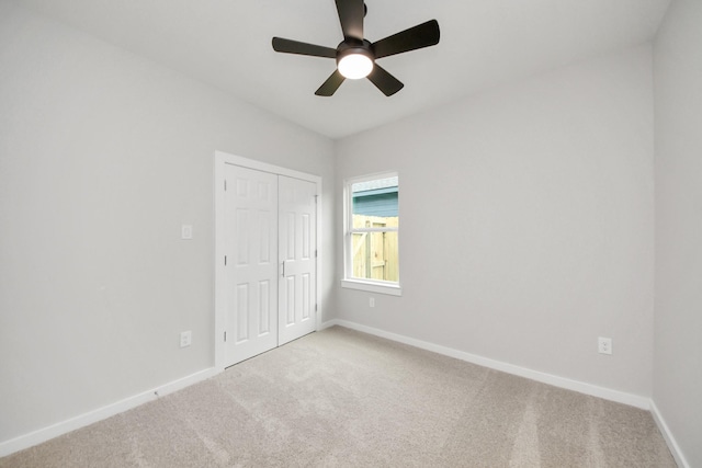 unfurnished bedroom featuring a closet, baseboards, carpet, and a ceiling fan