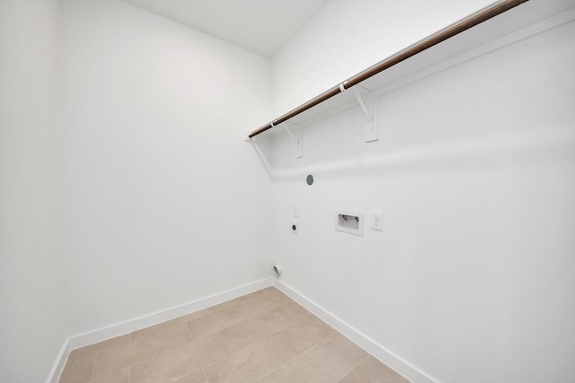 washroom with baseboards, hookup for an electric dryer, hookup for a washing machine, and laundry area