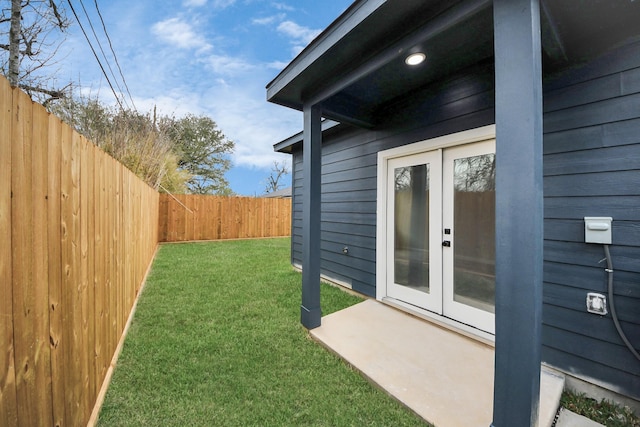 view of yard with french doors and a fenced backyard