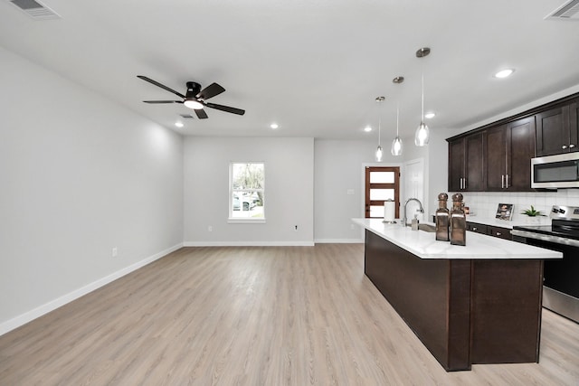 kitchen featuring light countertops, tasteful backsplash, visible vents, and appliances with stainless steel finishes