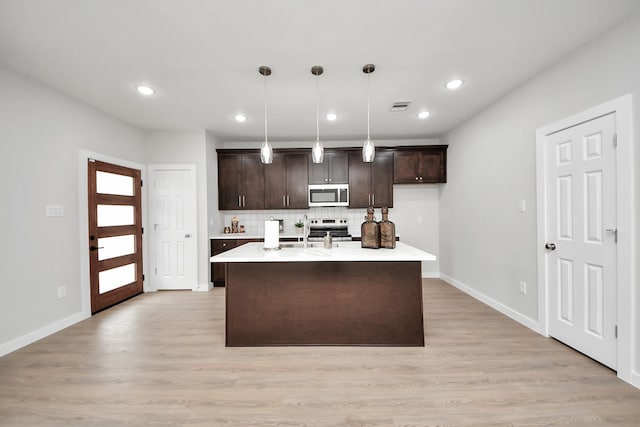 kitchen with visible vents, stainless steel appliances, dark brown cabinetry, light countertops, and light wood-type flooring