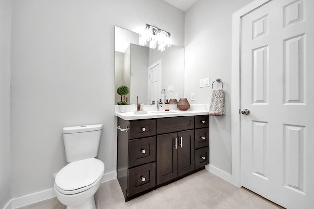 bathroom with vanity, toilet, baseboards, and tile patterned flooring