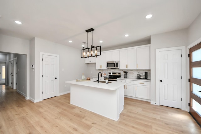 kitchen featuring tasteful backsplash, recessed lighting, stainless steel appliances, white cabinets, and light countertops