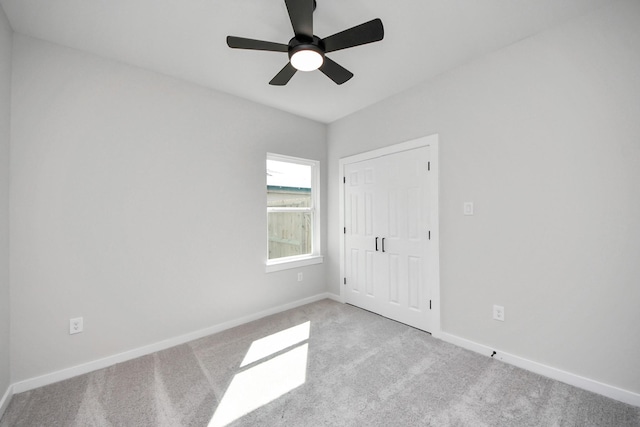 unfurnished bedroom featuring baseboards, carpet, and a ceiling fan