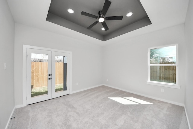 empty room featuring carpet flooring, french doors, baseboards, and a tray ceiling