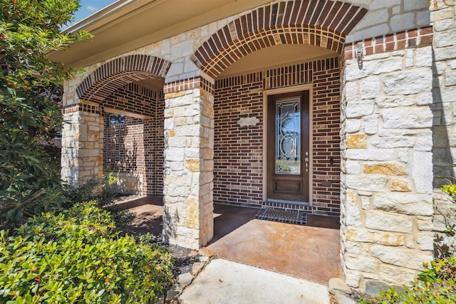 property entrance with brick siding and stone siding