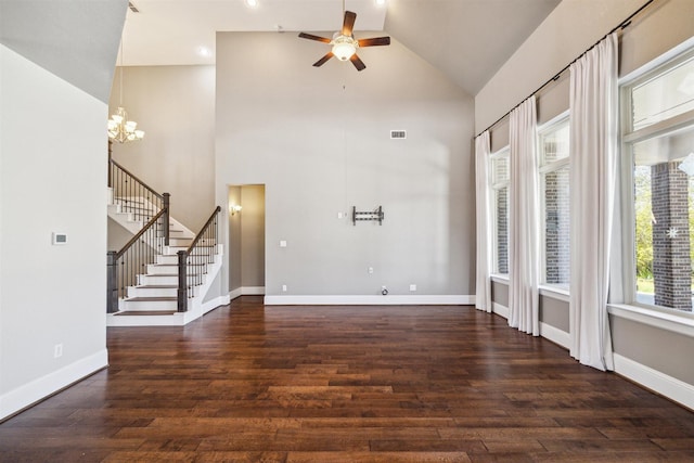 unfurnished living room featuring baseboards, stairway, ceiling fan with notable chandelier, wood finished floors, and high vaulted ceiling