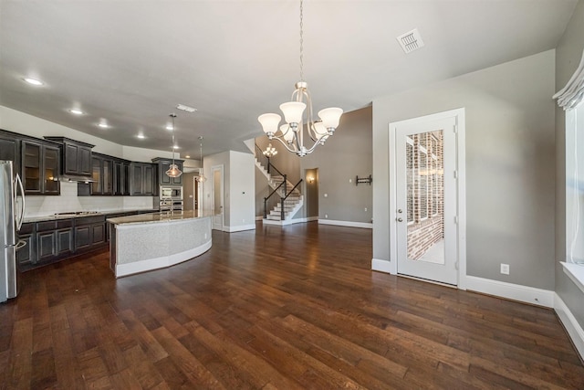 kitchen featuring light countertops, backsplash, dark wood-style flooring, and appliances with stainless steel finishes