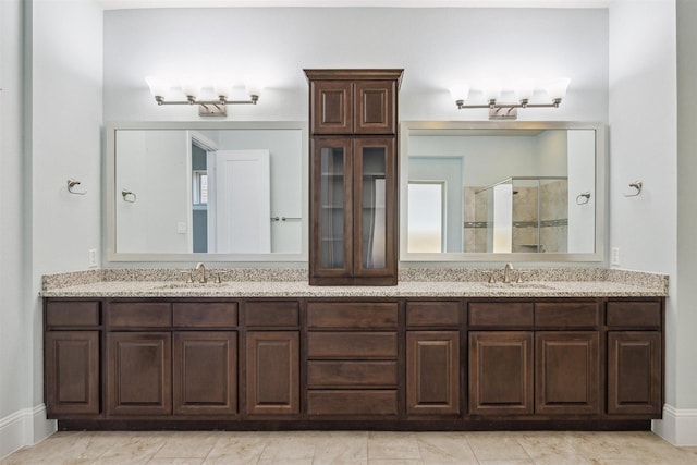 bathroom featuring a sink, double vanity, and a shower stall