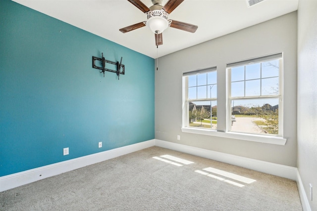 unfurnished room with visible vents, carpet, baseboards, and ceiling fan