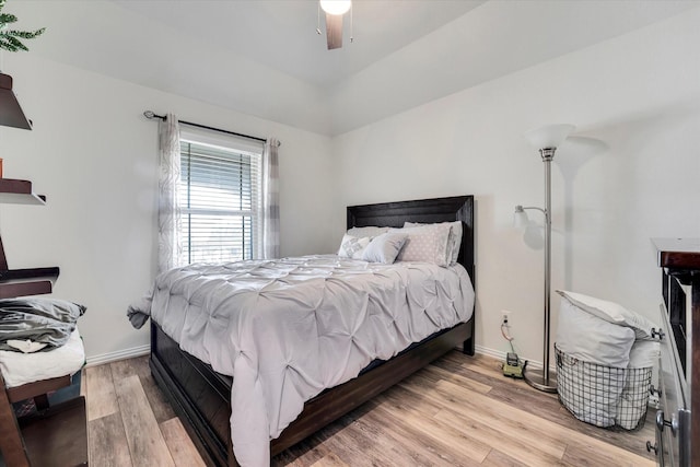 bedroom with a ceiling fan, wood finished floors, and baseboards