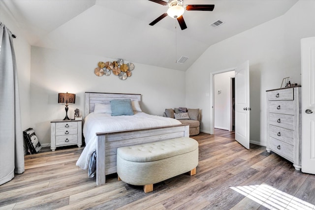 bedroom with visible vents, baseboards, wood finished floors, and vaulted ceiling