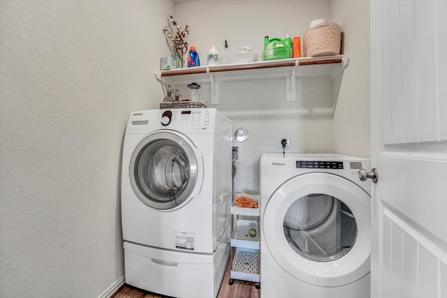 laundry area featuring laundry area, wood finished floors, and separate washer and dryer