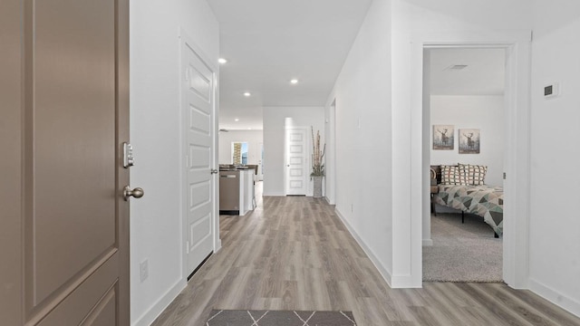 hall featuring recessed lighting, baseboards, and light wood-style floors