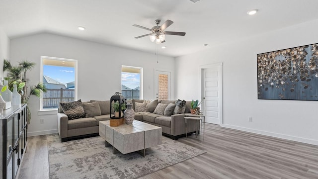 living area featuring a ceiling fan, recessed lighting, light wood finished floors, baseboards, and vaulted ceiling