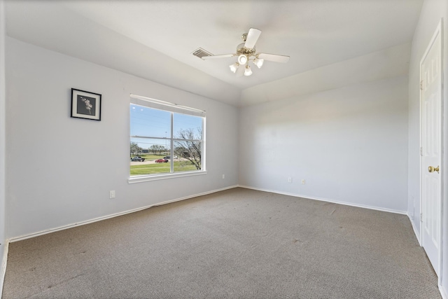 empty room with visible vents, lofted ceiling, carpet, baseboards, and ceiling fan