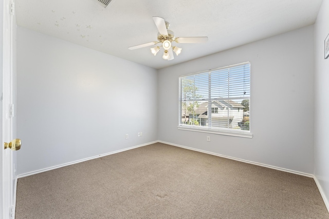 spare room featuring carpet flooring, baseboards, and a ceiling fan