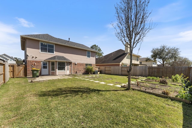 back of house with brick siding, a yard, a patio, and a fenced backyard