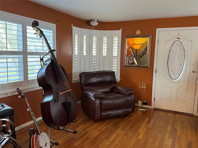 living area with baseboards and wood finished floors