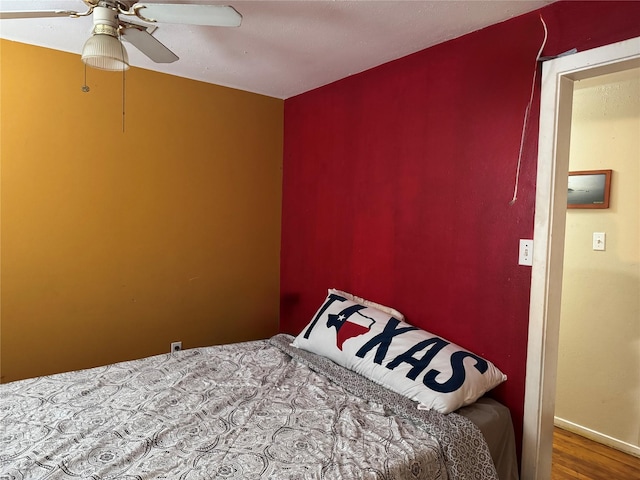 bedroom with a ceiling fan and wood finished floors