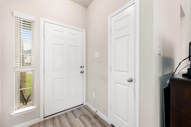 foyer entrance with baseboards and light wood finished floors