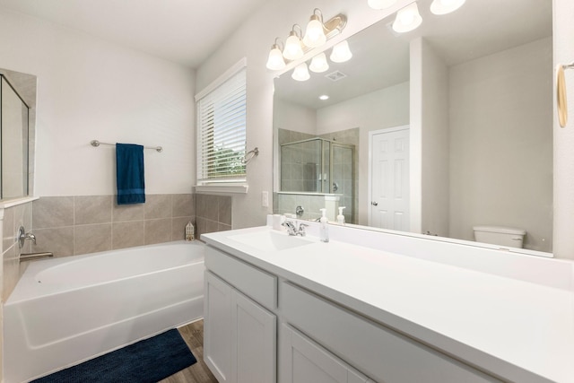 full bath with visible vents, toilet, a stall shower, wood finished floors, and a bath