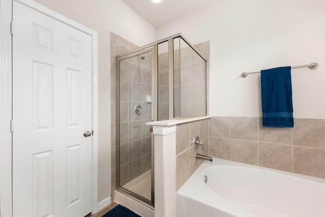 full bathroom with a garden tub and a shower stall