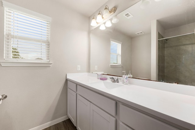 bathroom with visible vents, baseboards, wood finished floors, and vanity