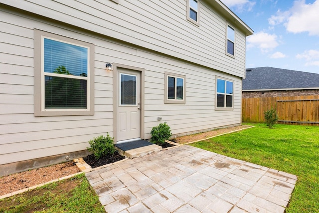 doorway to property with a yard, a patio, and fence