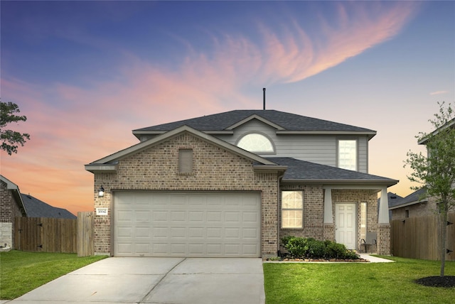 view of front facade with a front lawn, an attached garage, fence, and brick siding