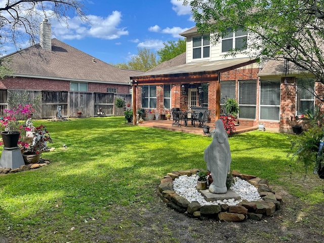 16815 Coronado Springs Dr, Spring, TX 77379 - rear view of house featuring fence, a patio, brick siding, a shingled roof, and a lawn