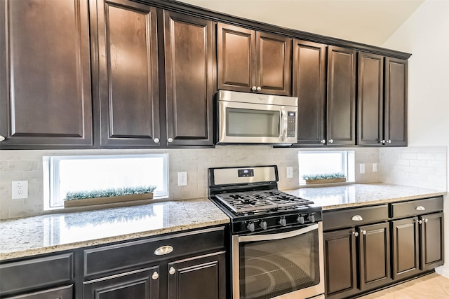 kitchen featuring light stone countertops, tasteful backsplash, and stainless steel appliances