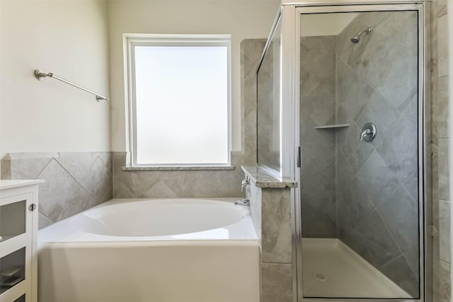 bathroom featuring vanity, a bath, and a shower stall