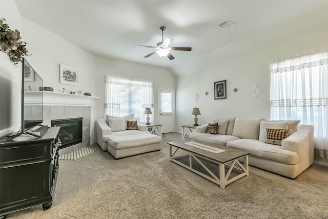 carpeted living room with visible vents, a tile fireplace, and ceiling fan