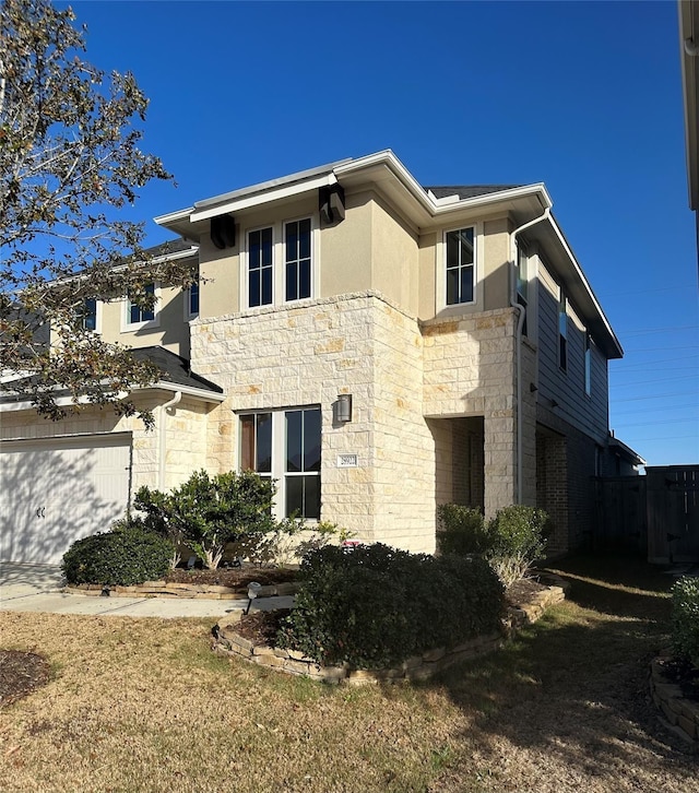 view of front facade featuring stucco siding, stone siding, and a garage