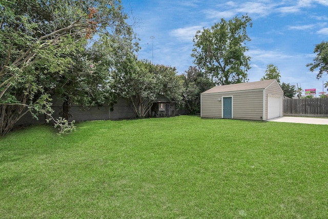 view of yard with an outbuilding, a detached garage, and a fenced backyard