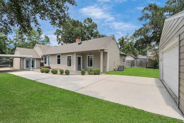 view of front of home with fence, a front yard, a shingled roof, central AC unit, and a chimney