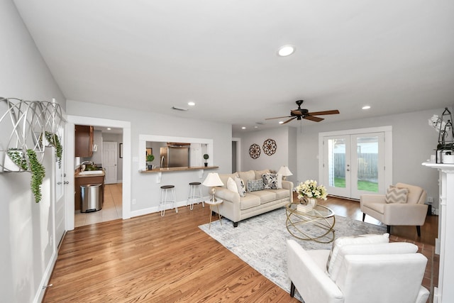 living room featuring visible vents, baseboards, light wood-type flooring, recessed lighting, and french doors