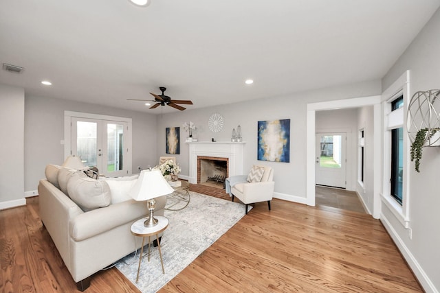 living area featuring recessed lighting, visible vents, light wood-style flooring, and baseboards