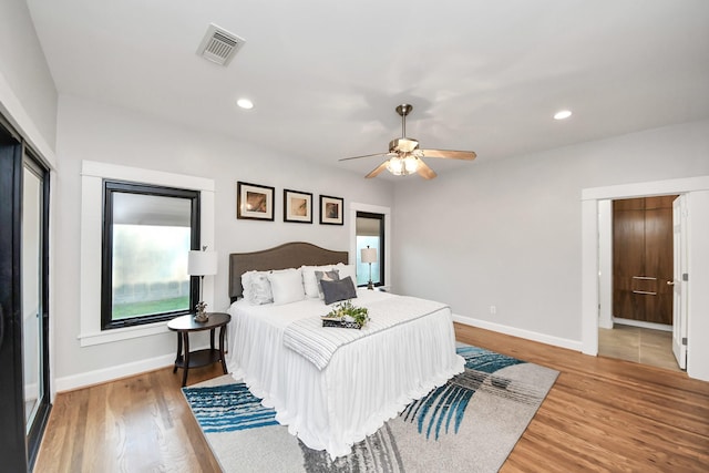 bedroom with recessed lighting, visible vents, baseboards, and wood finished floors