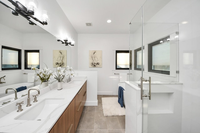 bathroom featuring a shower stall, double vanity, tile patterned floors, and a sink