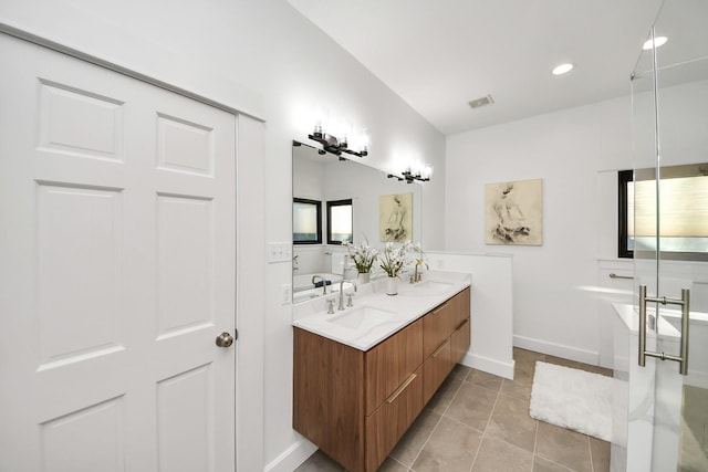 bathroom with visible vents, a sink, tile patterned flooring, double vanity, and baseboards