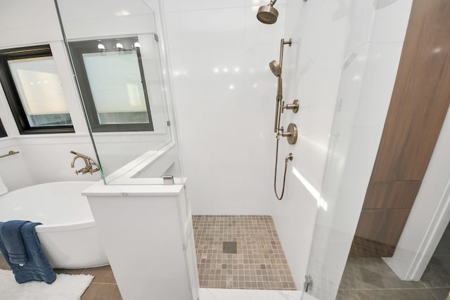 full bath featuring tile patterned floors, a stall shower, and a freestanding bath