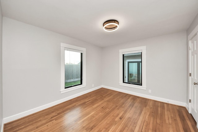 spare room with light wood-style floors and baseboards