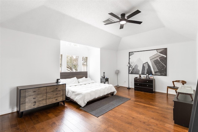 bedroom featuring visible vents, wood-type flooring, baseboards, ceiling fan, and vaulted ceiling