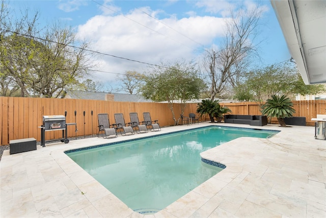 view of swimming pool featuring grilling area, a fenced in pool, a fenced backyard, and a patio area