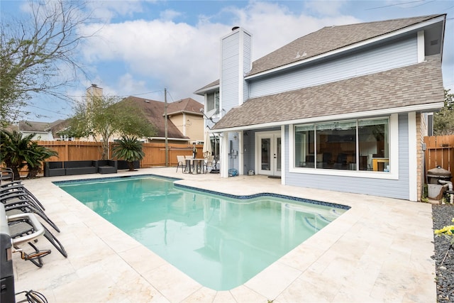 view of swimming pool with french doors, a patio area, a fenced in pool, and a fenced backyard